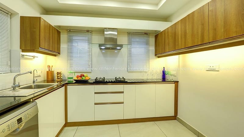 U-shaped modular kitchen in Hyderabad with wood and glossy white cabinets, stainless chimney and granite countertop