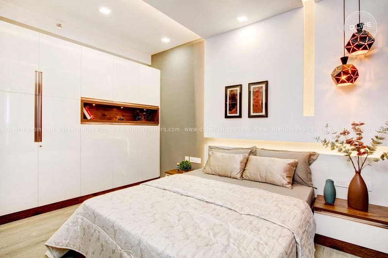 Bedroom with floor-to-ceiling white wardrobes, beige bedspread and twin geometric pendant lights, Hyderabad home