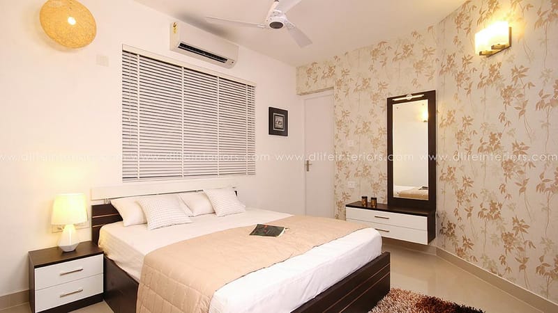 Bedroom with floral accent wallpaper, dark-and-white bed, mirrored dresser and venetian blinds, Hyderabad