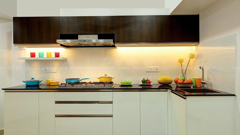Straight modular kitchen in Hyderabad with white base units, walnut overheads, black granite counter and gas hob