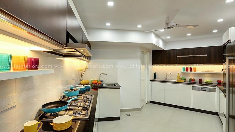 Spacious L-shaped kitchen in Hyderabad with white cabinets, walnut overheads, gas hob and recessed-lit false ceiling