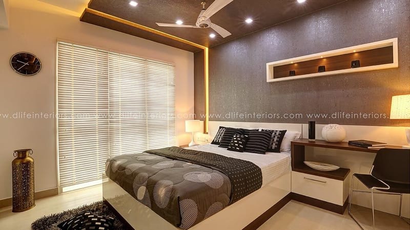 Master bedroom with textured headboard wall, gold cove-lit false ceiling, lit niche shelf and built-in study desk, Hyderabad
