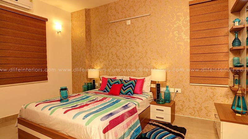 Bedroom featuring gold damask wall, wooden blinds, bedside lamps and open display shelving with blue glassware, Hyderabad