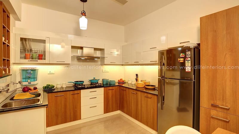 U-shaped modular kitchen with wood and white cabinets, black countertop, chimney and stainless steel fridge, Hyderabad