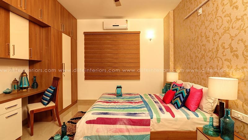 Bedroom with two-tone wood wardrobe, corner study desk, striped bedspread and gold floral accent wall, Hyderabad