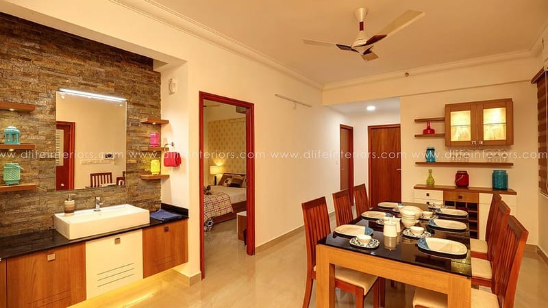 Dining area with stone-clad washbasin counter, six-seater wood table set and open doorway to bedroom, Hyderabad