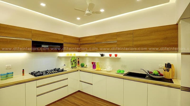 L-shaped modular kitchen pairing wood-grain wall cabinets with white base units and gas hob, Hyderabad home