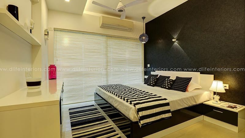 Bedroom with black feature wall, blackout blinds and striped bed runner beside a wood platform bed, Hyderabad