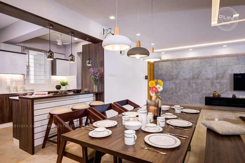 Open dining and kitchen with wooden table set, layered dome pendants and a grey stone TV wall, Vijayakumar home, Hyderabad