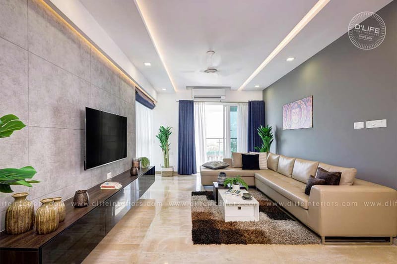 Living room with cream leather sectional, marble flooring, stone-tile TV wall and deep-blue curtains, Vijayakumar home