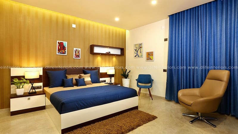 Bedroom with fluted wood headboard wall, blue bedspread, royal-blue curtains and a tan swivel chair, Hyderabad