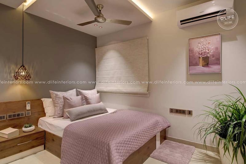 Blush-toned bedroom in Hyderabad with wood platform bed, mauve quilt, woven headboard and geometric pendant light
