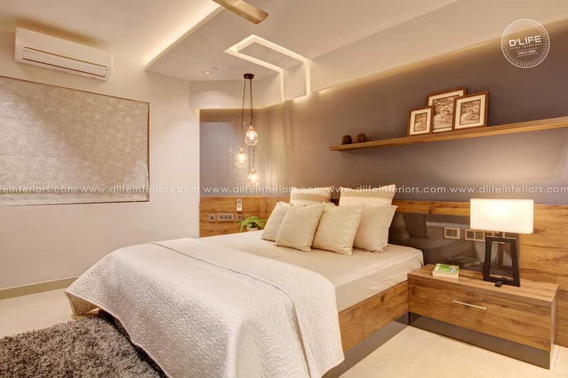 Warm-lit bedroom in Hyderabad with wood headboard, cluster pendant lights and a floating shelf of framed art
