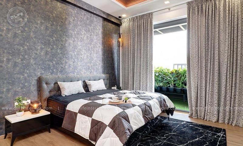 Bedroom with textured grey accent wall, sheer drapes, checkered bedspread and a black marble rug, Hyderabad