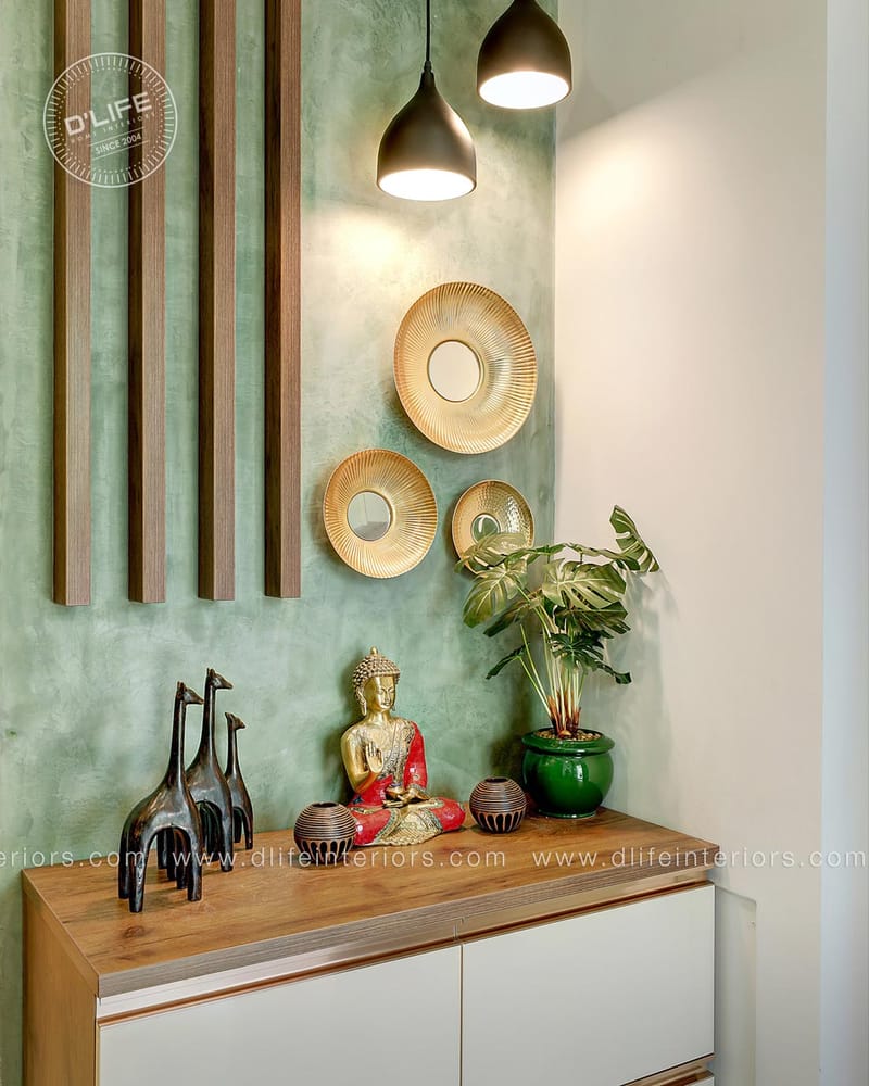 Entryway console with green textured wall, gold sunburst mirrors, Buddha figurine and brass pendants, Hyderabad