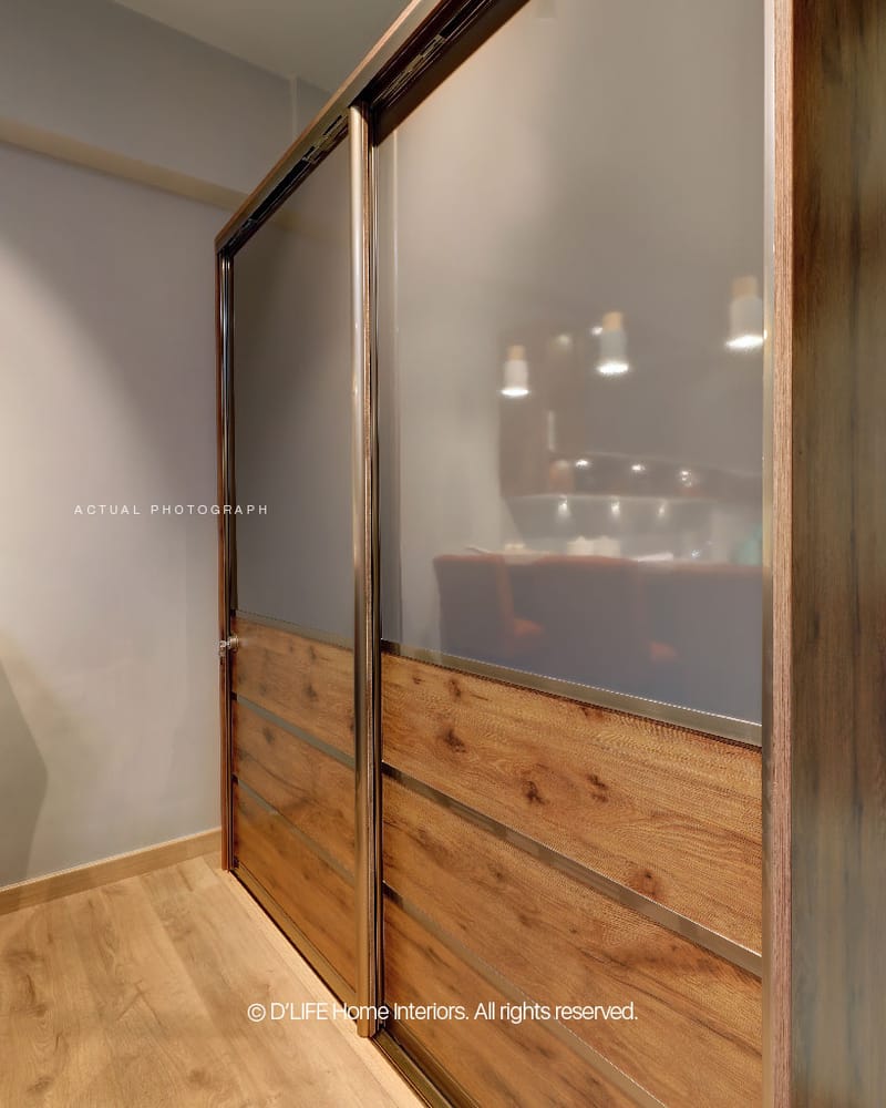 Frosted-glass sliding wardrobe with horizontal wood-grain panels and slim metal handles on a laminate floor, Hyderabad