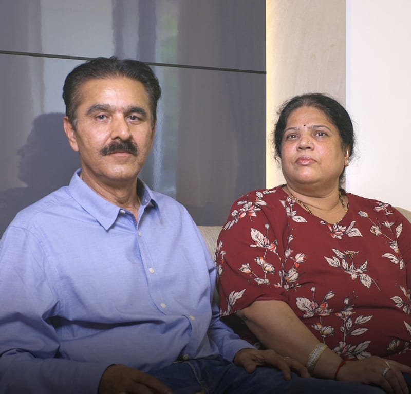 Portrait of homeowners Mr Surendra and family seated against a curtained wall, Dlife Interiors client, Hyderabad