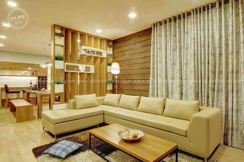 Living room with cream L-shaped leather sofa, slatted wood partition and patterned floor-length curtains, Hyderabad