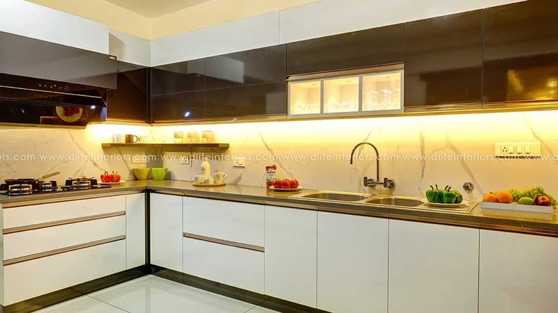 L-shaped modern kitchen in Hyderabad with glossy white base units, dark glass uppers and warm under-cabinet lighting