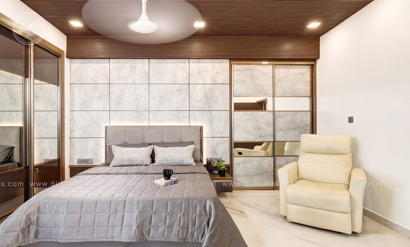 Master bedroom with marble-panelled sliding wardrobes, warm wooden-slat ceiling and a cream leather recliner, Hyderabad