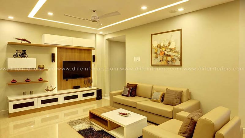Compact living room with beige L-shaped sofa, wall-mounted TV cabinet and framed abstract painting, Hyderabad