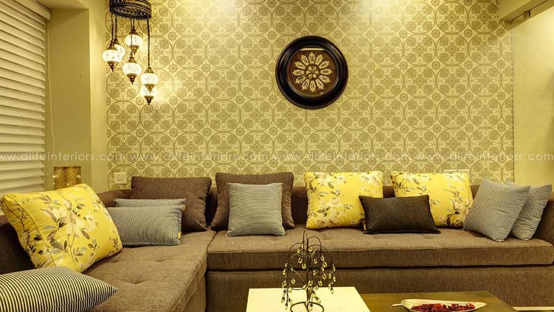 Living room with brown fabric sectional, yellow floral cushions, damask wallpaper, Turkish pendant lamps, Hyderabad