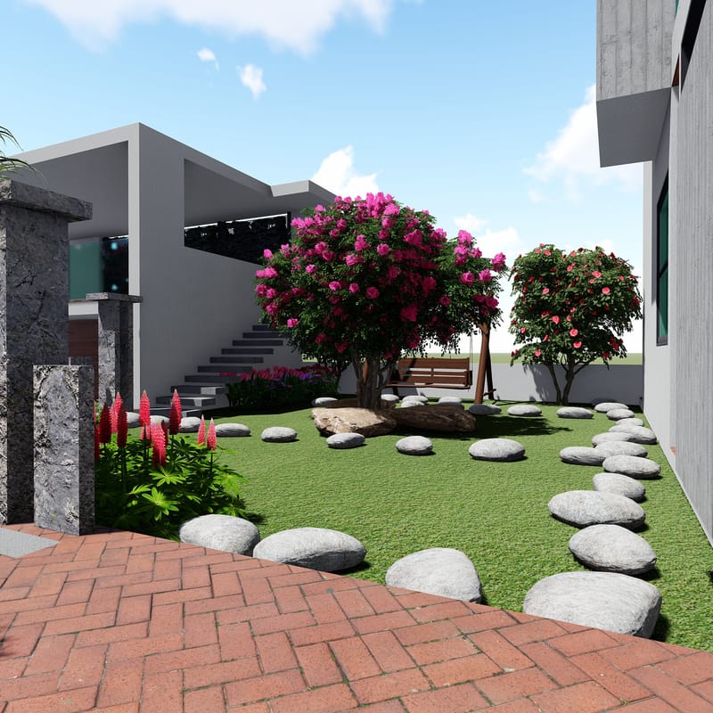 Landscaped villa garden with stepping stones across a lawn, a pink flowering tree and red-brick paving in Hyderabad