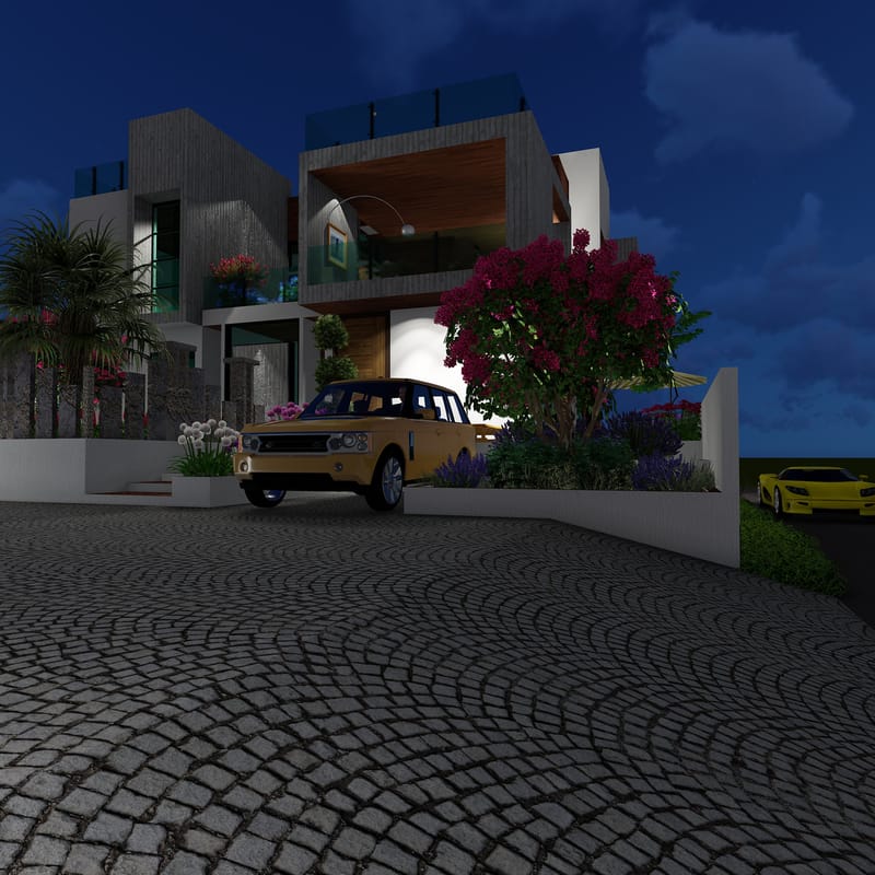 Modern villa lit at night with a cobblestone driveway, parked cars and a flowering crepe-myrtle by the entrance, Hyderabad