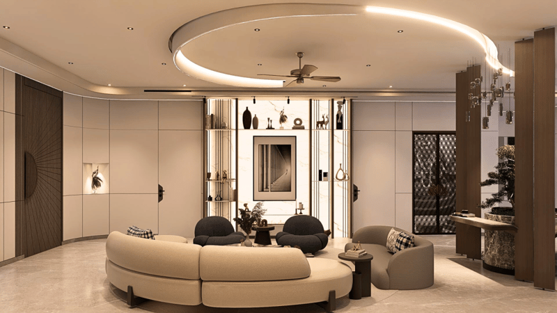 Modern living room with curved cream sofa, charcoal bouclé chairs and lit display niches under a sweeping cove ceiling, Hyderabad