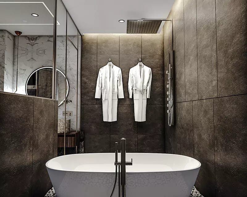 Dark stone bathroom with freestanding tub, rain shower, round mirror and twin white robes, Hyderabad