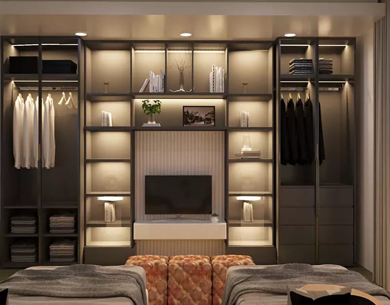Walk-in wardrobe with open backlit shelving, hanging rails, central TV niche and tufted bench, Hyderabad
