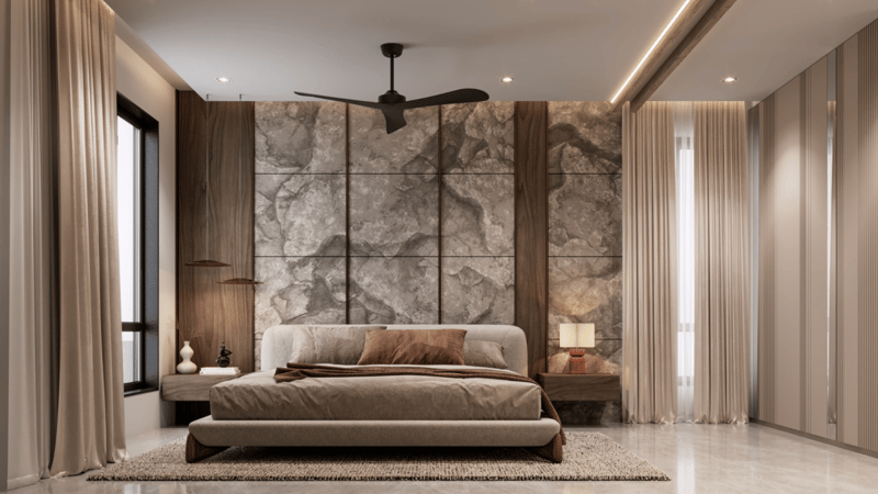 Platform bed below floor-to-ceiling beige marble headboard panels, framed by sheer drapes and a slim ceiling fan