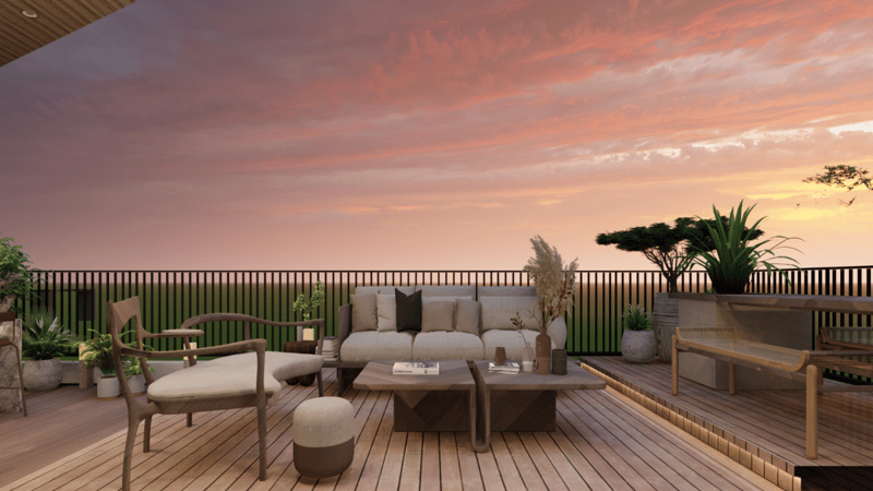 Open deck terrace with cushioned sofa, wood chairs and pampas grass under a pink dusk sky, Hyderabad