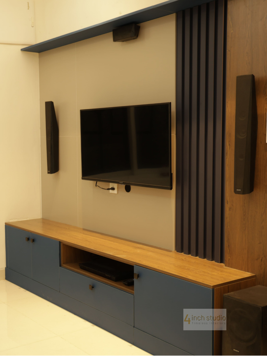 TV unit with wall-mounted screen, charcoal fluted panel, woodgrain accent and navy floating console, Hyderabad