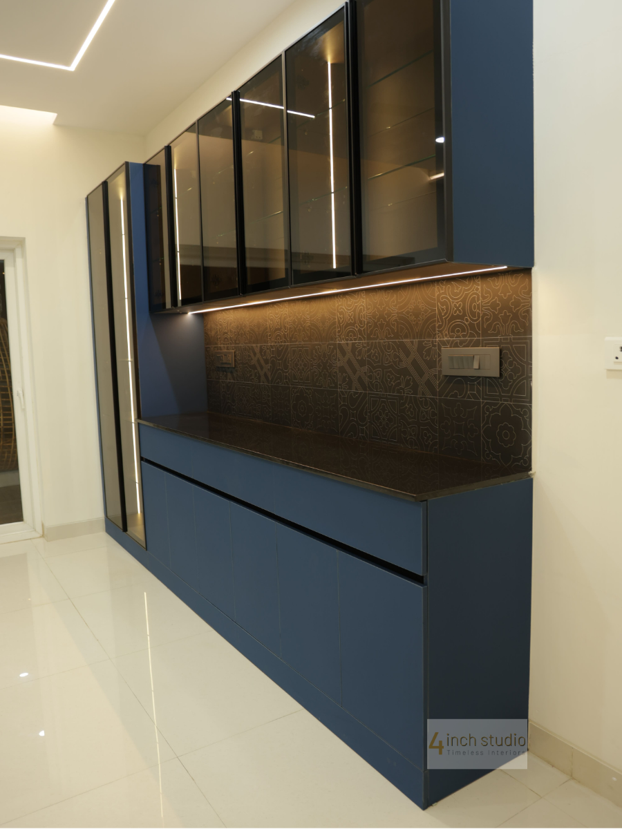 Navy blue crockery cabinet with glass-shelf uppers, dark patterned tile backsplash and glossy white floor, Hyderabad