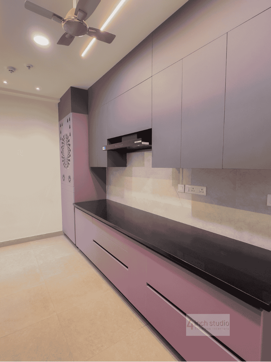 Modular kitchen in mauve and grey with black granite counter, glossy backsplash and tall storage, Hyderabad
