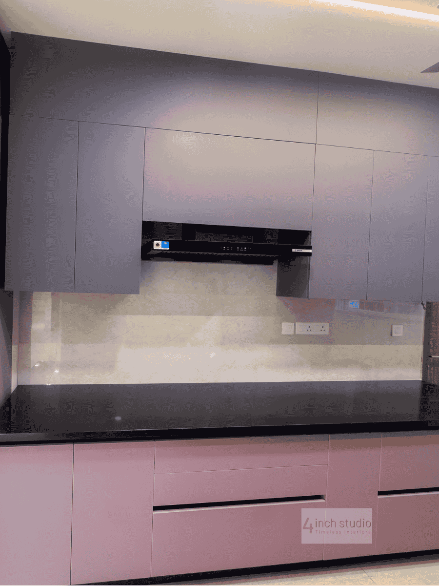 Modular kitchen in grey and blush pink with black granite worktop and built-in chimney, Hyderabad apartment