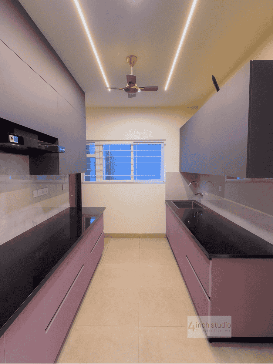 Parallel modular kitchen in mauve with glossy finish, black countertops and a bright window, Hyderabad