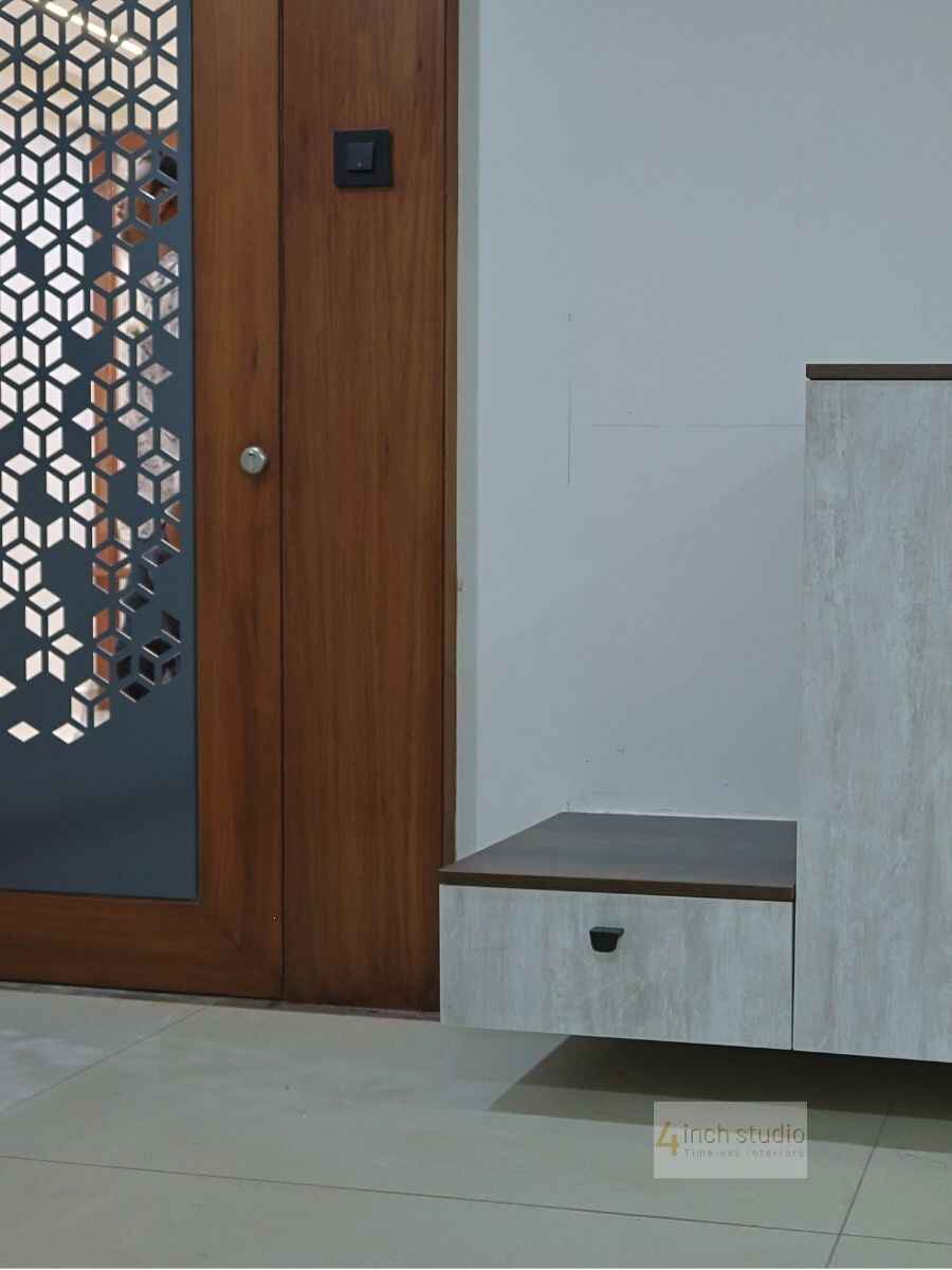 Entry corner with teak jali door panel and a wood-and-stone bench drawer unit, Hyderabad apartment foyer