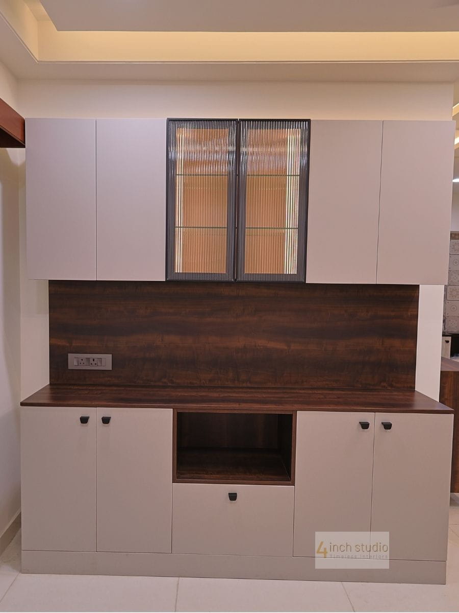 Crockery storage unit with white shutters, fluted-glass cabinet doors and dark woodgrain backsplash panel, Hyderabad