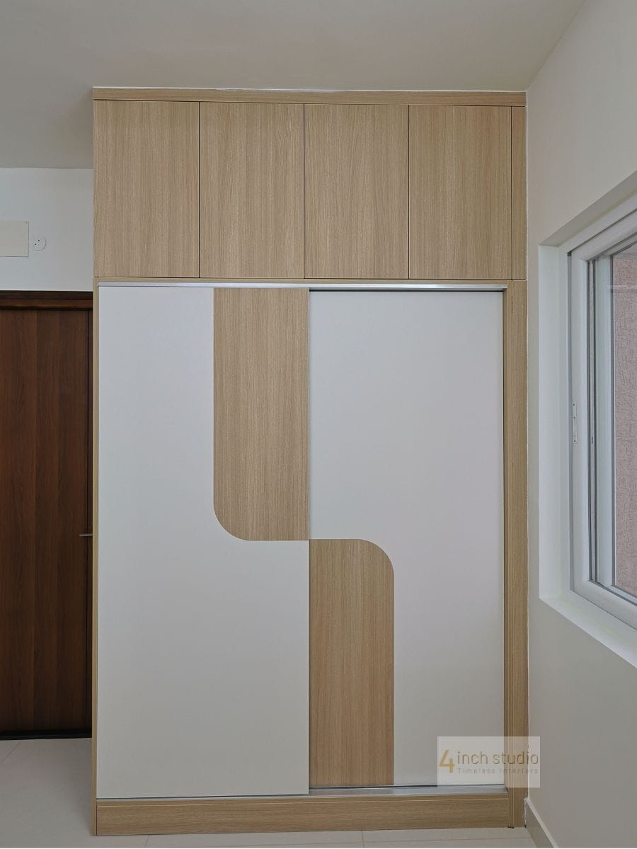 Sliding wardrobe in light oak laminate with white panels and curved cut-out motif plus overhead loft storage, Hyderabad