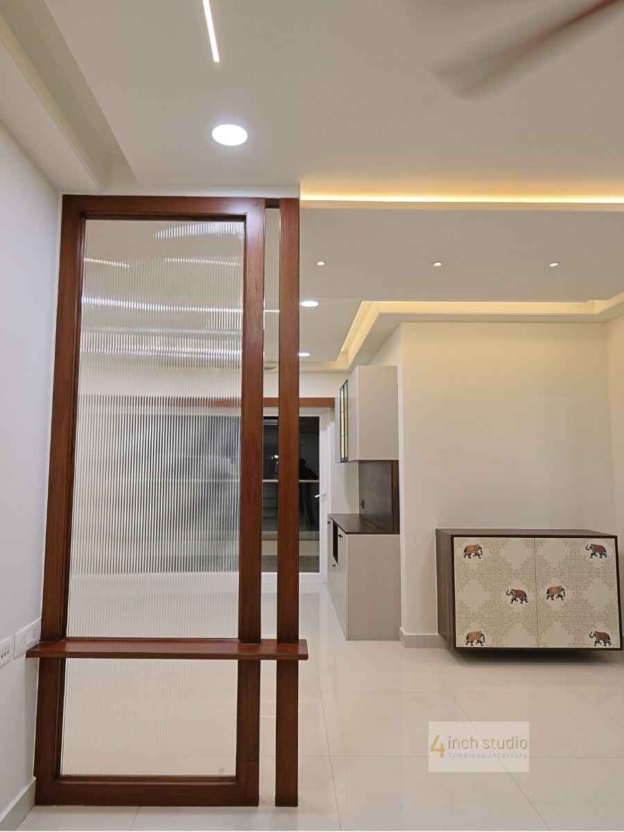 Foyer with a fluted-glass teak partition and bench leading to a kitchen, with elephant-print cabinet, Hyderabad