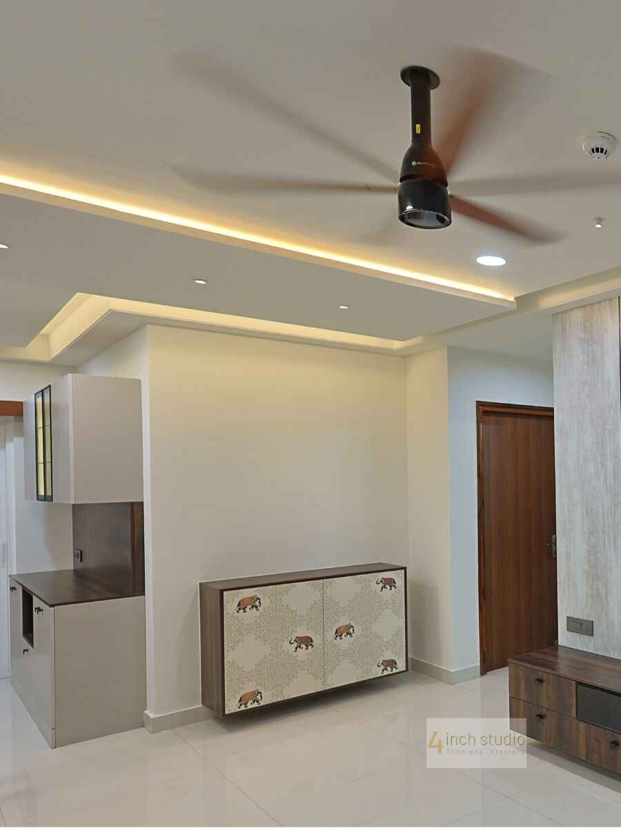 Hyderabad living room with layered false ceiling, recessed lights and a printed elephant-motif storage cabinet