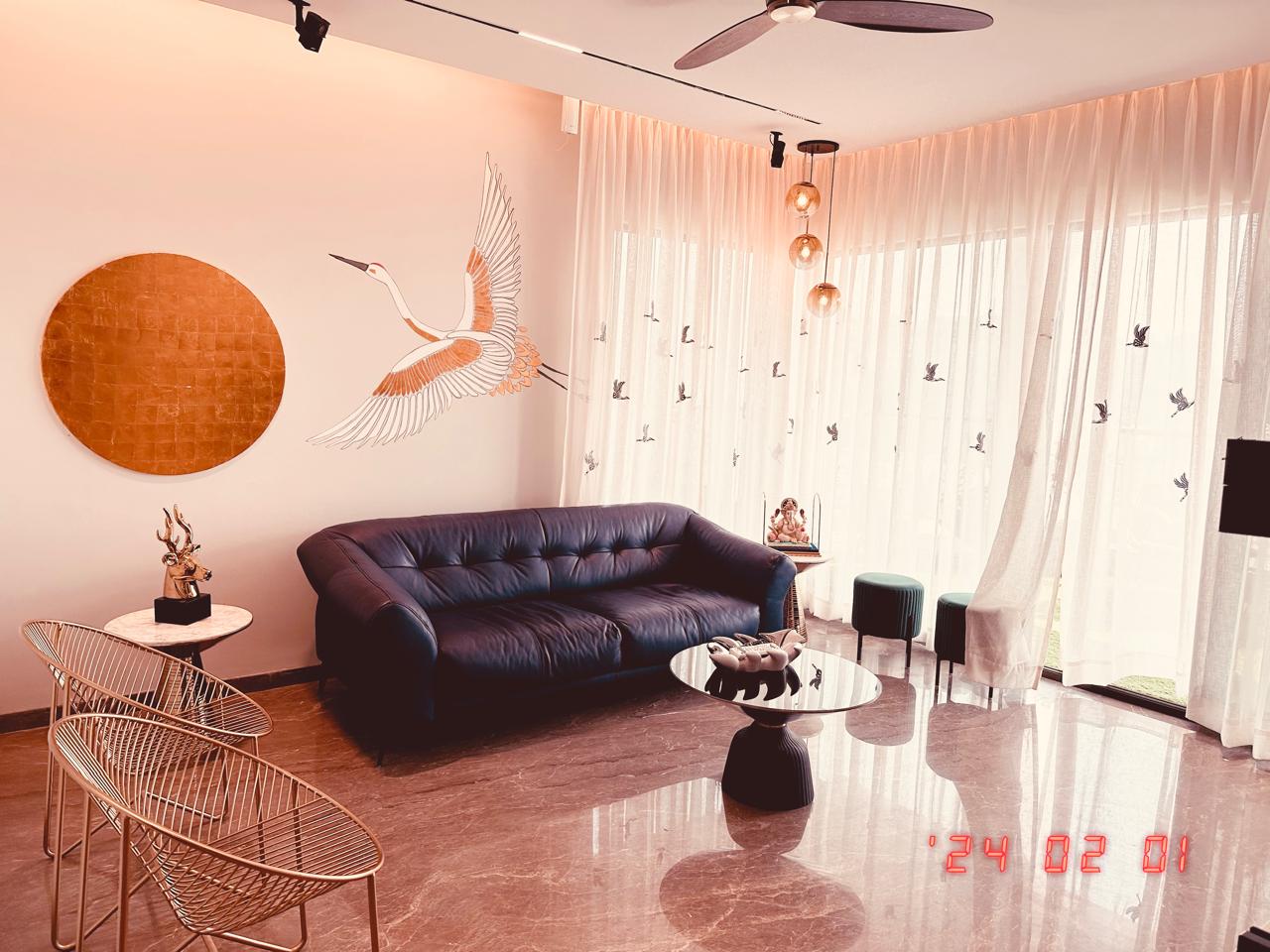 Warm-toned living room in Hyderabad with tufted navy sofa, crane wall mural, sheer bird-print drapes and glossy marble floor